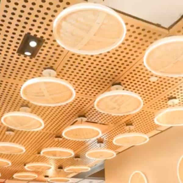 A ceiling with a wooden slatted design and circular, glowing light fixtures resembling dim sum steamers.